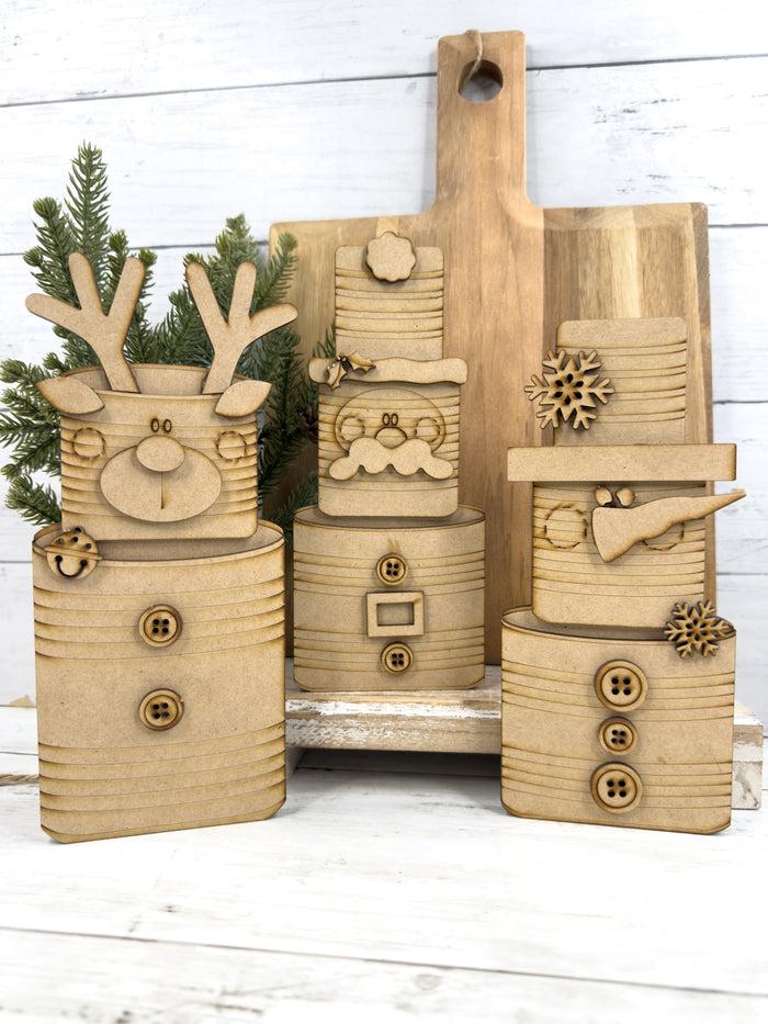 Unfinished Santa, snowman and reindeer Tin Can Christmas wood craft kits shown assembled before painting