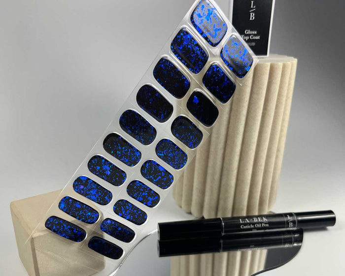 Blue Ice Speckle semi-cured gel nail wraps on a nail mock-up, alternate angle